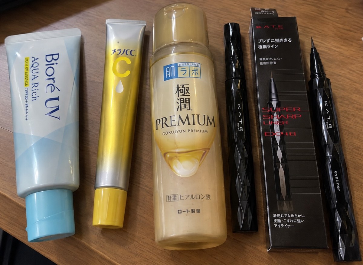 Four Japanese drugstore beauty products: Biore UV Aqua Rich sunscreen, Melano CC Medicated Intensive Spot Treatment Serum, a Hada Labo Gokujyun Premium Lotion bottle, and KATE Super Sharp Liner EX4.0 with its box